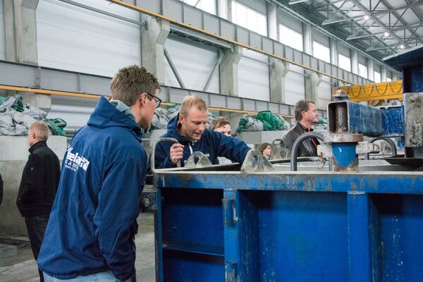 Nysjerrige deltakere på turen studerer en form hvor det støpes pile caps